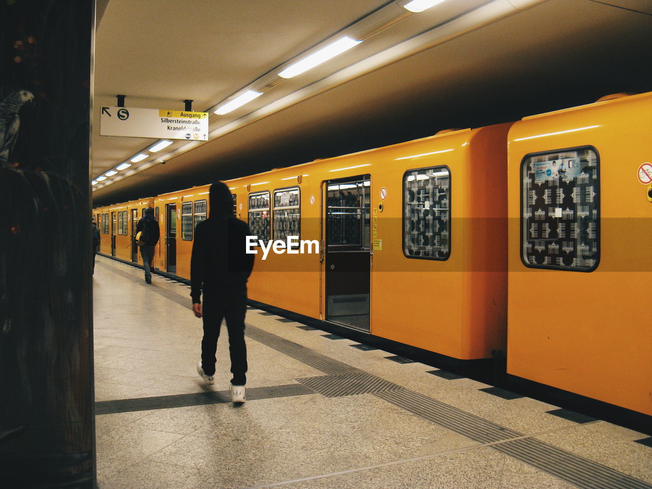 Rear view of person walking at railroad station platform