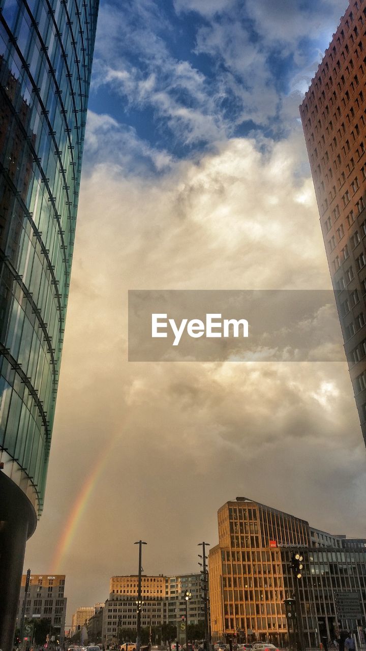 LOW ANGLE VIEW OF MODERN BUILDINGS AGAINST CLOUDY SKY