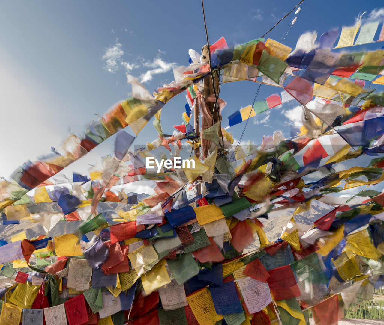 Low angle view of colorful prayer flags hanging against sky