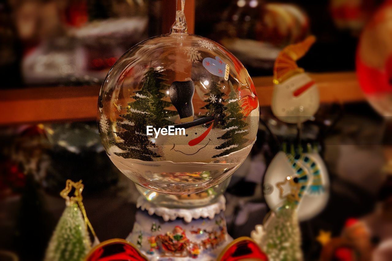 CLOSE-UP OF CHRISTMAS DECORATIONS HANGING ON TABLE