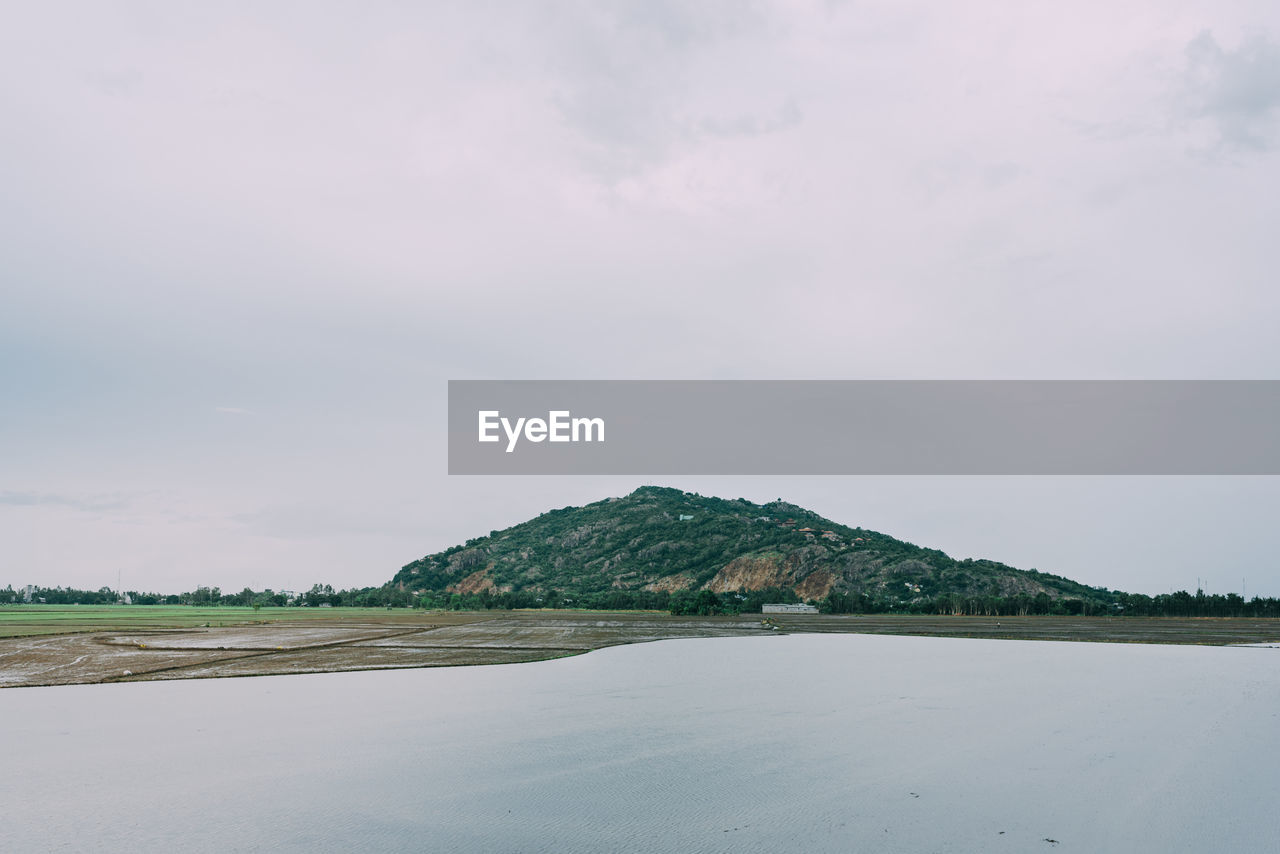 Scenic view of land and mountains against sky