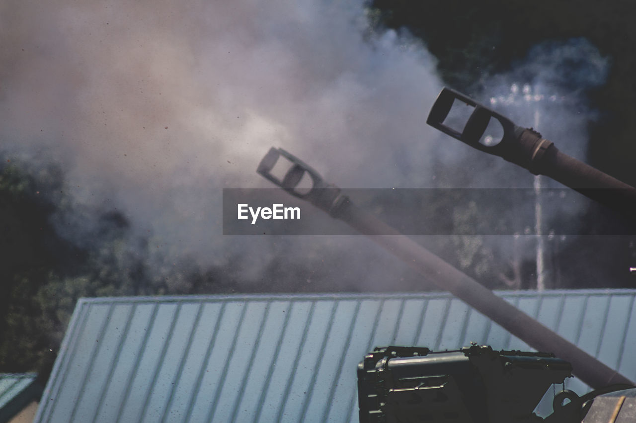 Low angle view of weapon and smoke during war