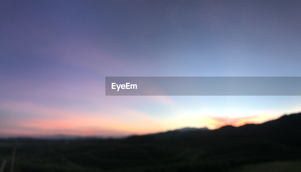 SCENIC VIEW OF DRAMATIC SKY OVER SILHOUETTE LANDSCAPE