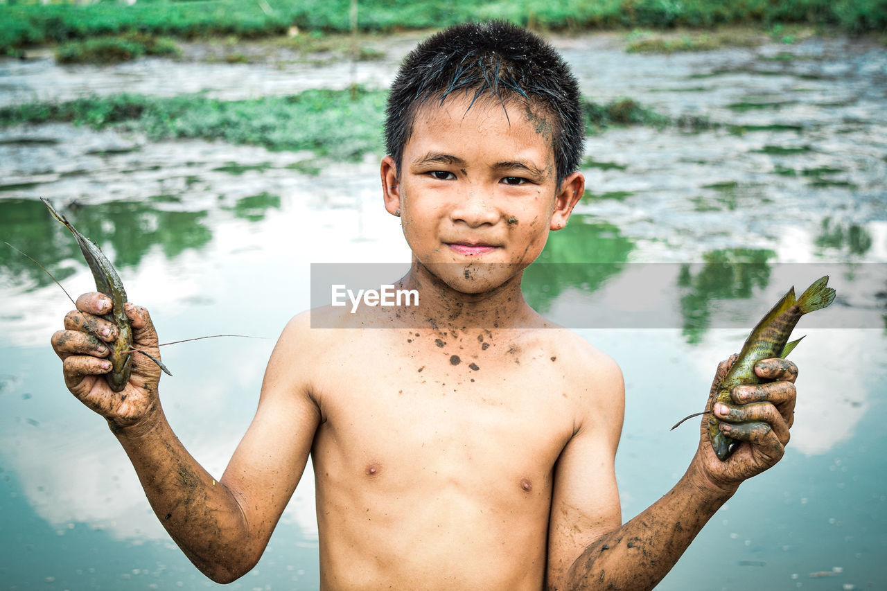 Portrait of shirtless man fishing