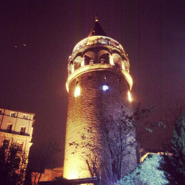 LOW ANGLE VIEW OF ILLUMINATED BUILDING AT NIGHT