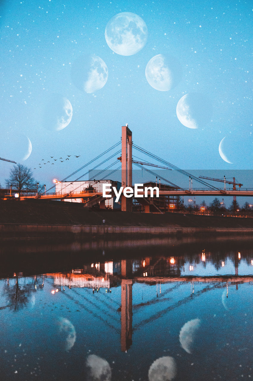 Bridge over river against sky at night