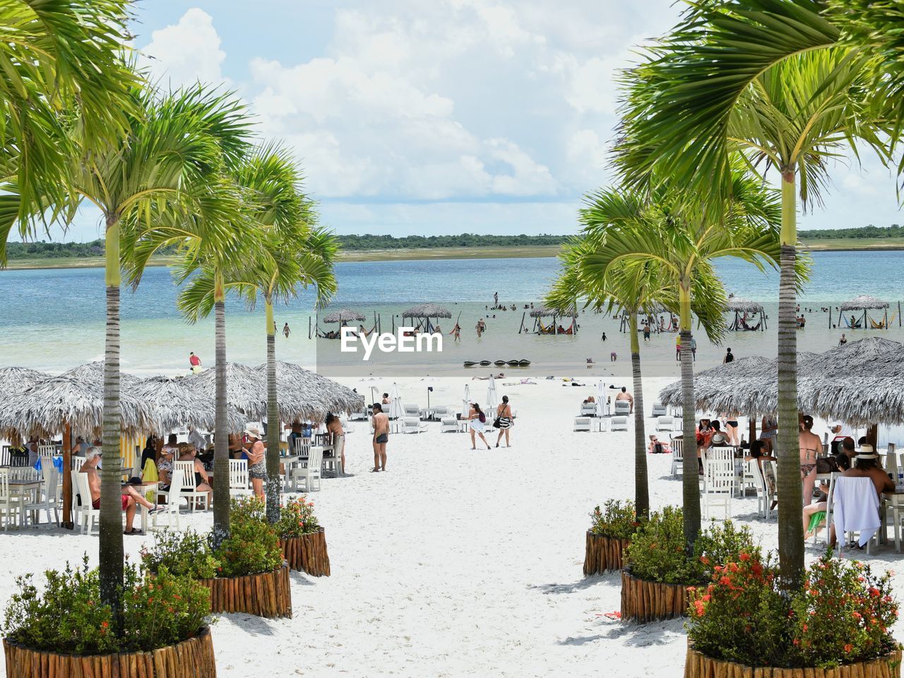 View of tourist on beach against cloudy sky