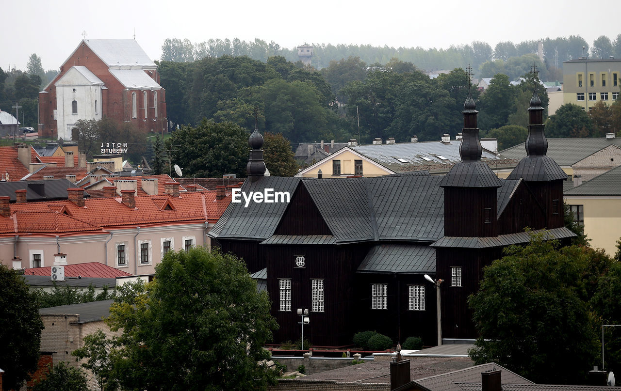 HIGH ANGLE VIEW OF HOUSES AND TREES AGAINST SKY