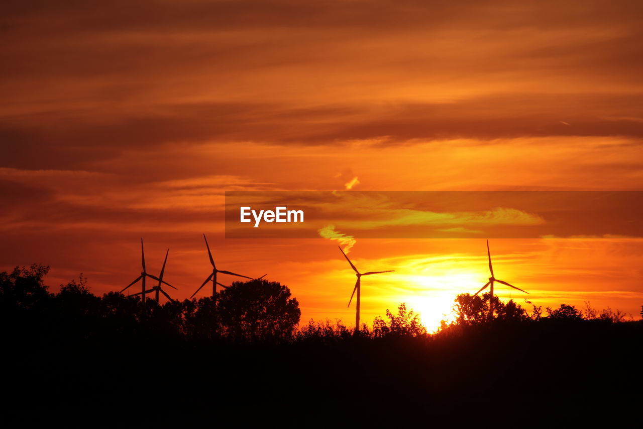 SILHOUETTE OF WINDMILL ON FIELD DURING SUNSET