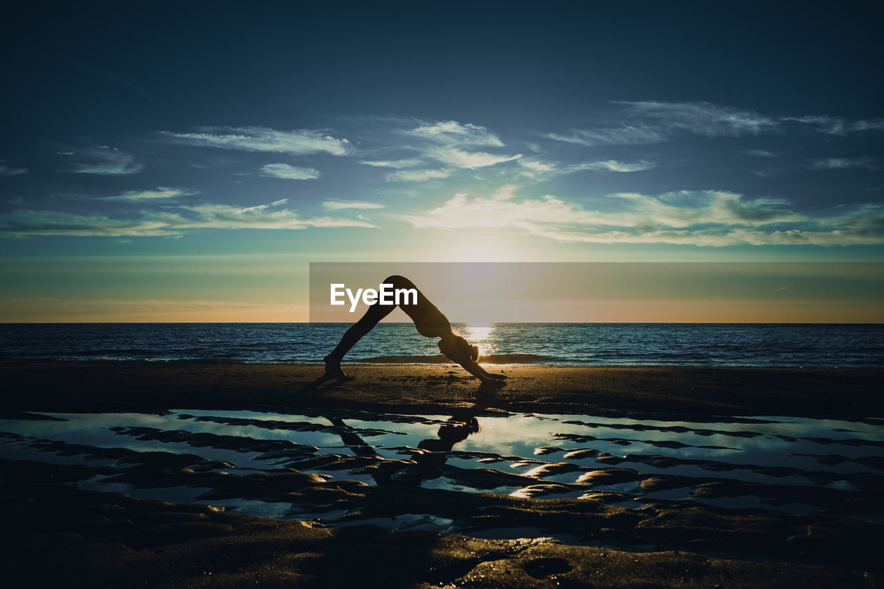 SILHOUETTE PERSON AT BEACH DURING SUNSET