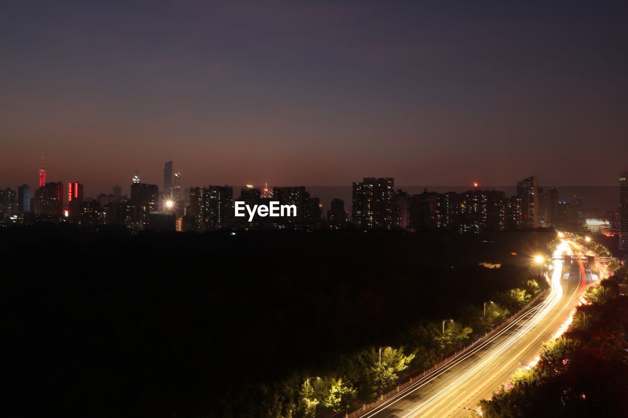 Illuminated city against sky at night