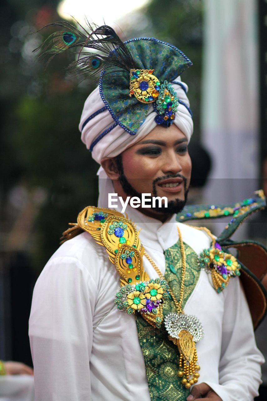 Smiling man wearing traditional clothing during festival