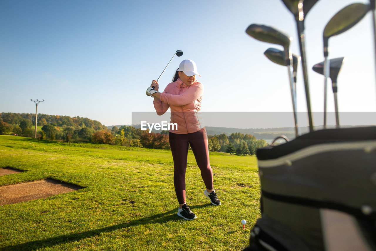 FULL LENGTH OF MAN STANDING ON GOLF COURSE AGAINST SKY