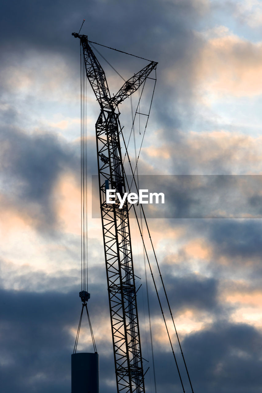 LOW ANGLE VIEW OF SILHOUETTE CRANES AGAINST SKY