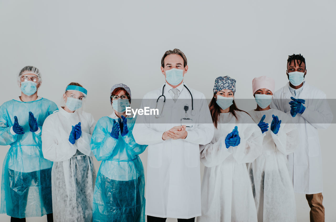 Portrait of doctors standing against white background