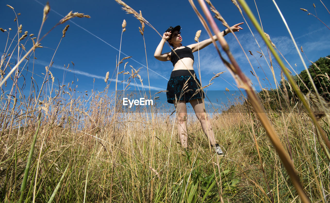 Full length of young woman standing on grass