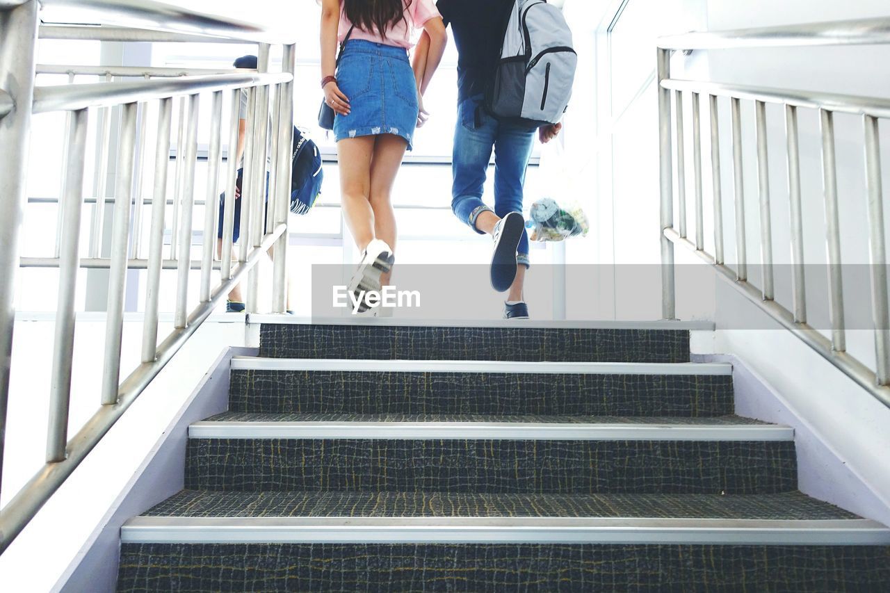 Low angle view of couple climbing stairs at airport