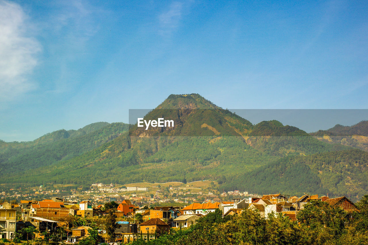 Townscape by mountain against blue sky at batu, east java, indonesia