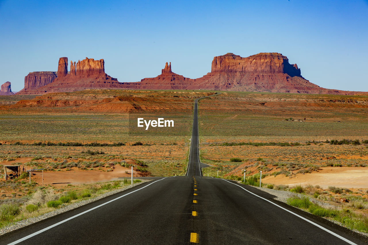 ROAD AMIDST ROCK FORMATIONS AGAINST SKY