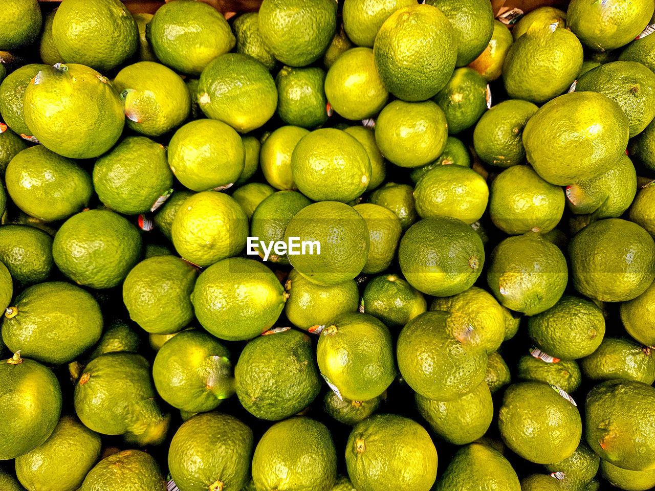 Stack of limes in display at grocery store for retail sale.