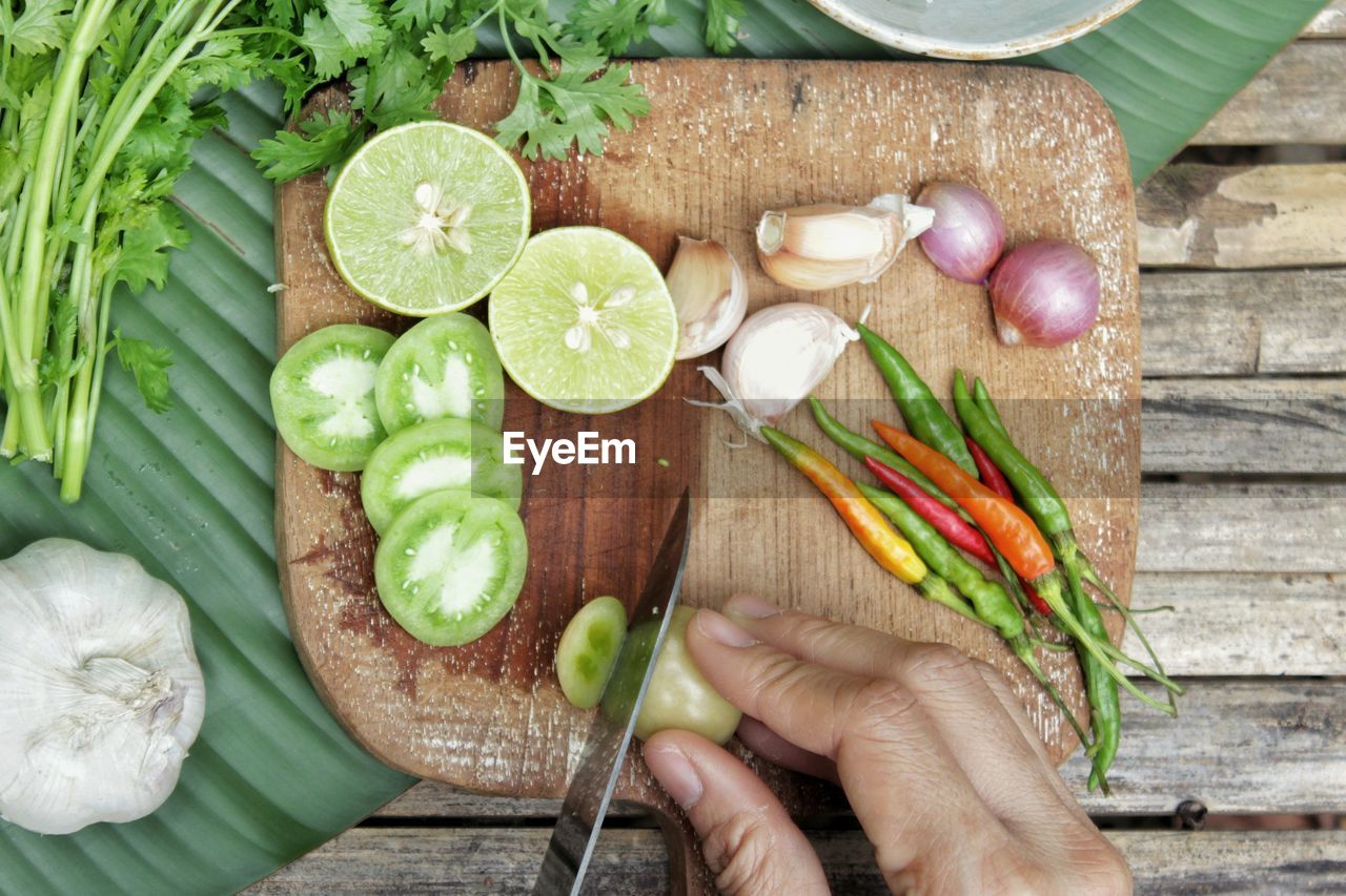 Directly above shot of cropped hands cutting vegetable