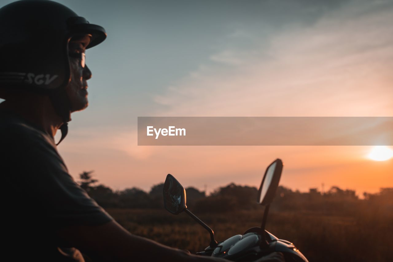 PORTRAIT OF MAN RIDING MOTORCYCLE AGAINST SKY