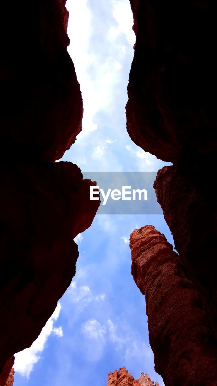 Low angle view of rock formation against cloudy sky