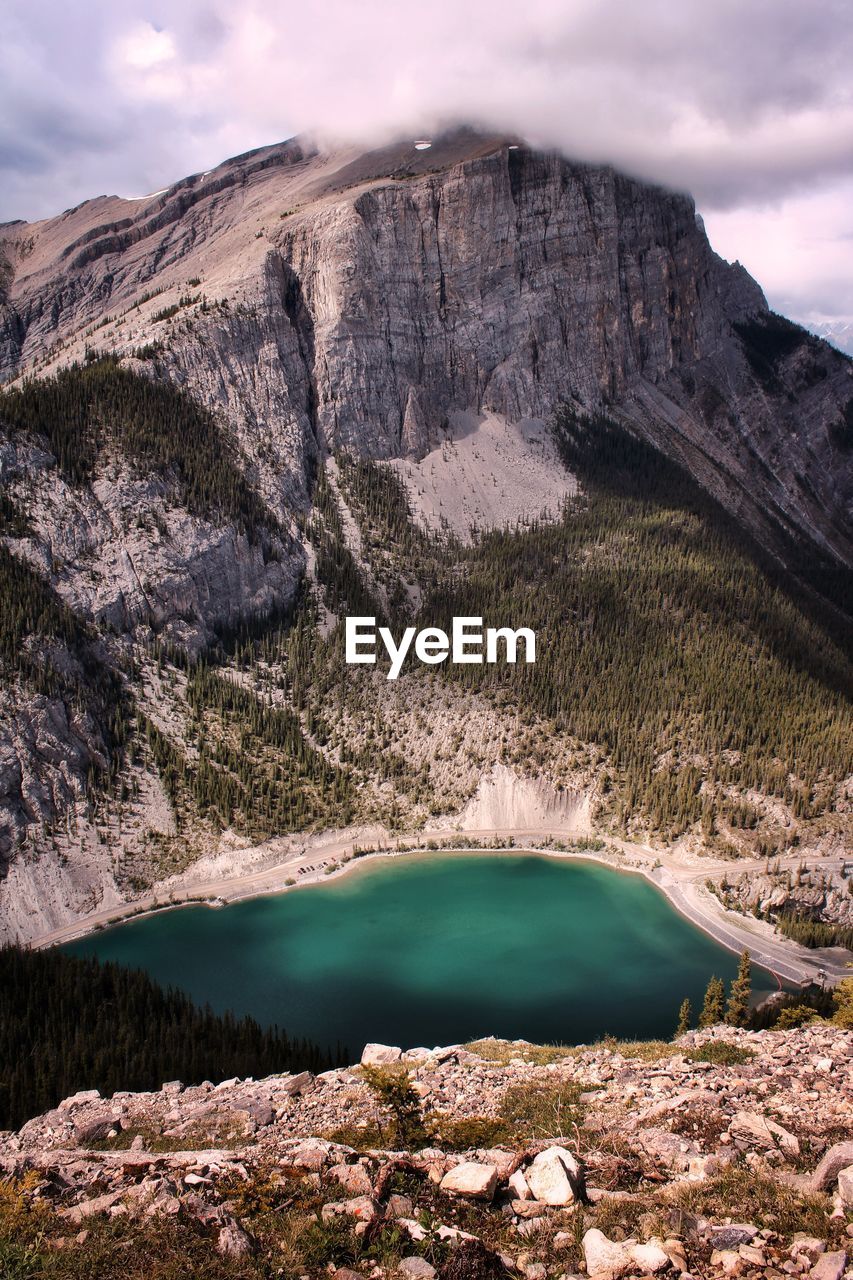 Scenic view of turquoise lake and mountains against sky