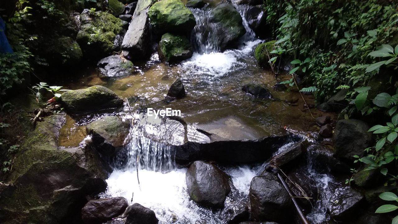 HIGH ANGLE VIEW OF WATERFALL IN RIVER