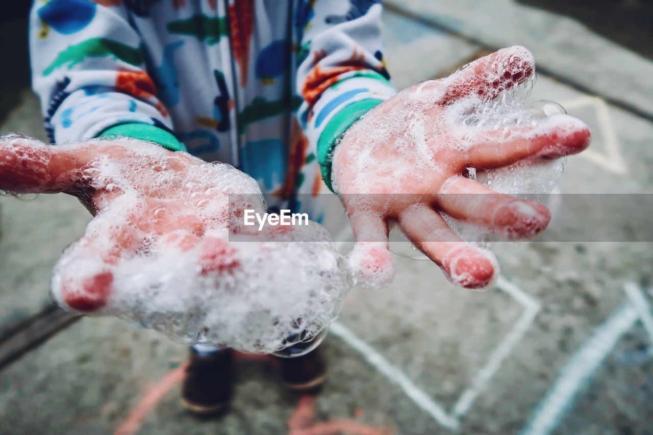 Close-up of hand covered in soap sud