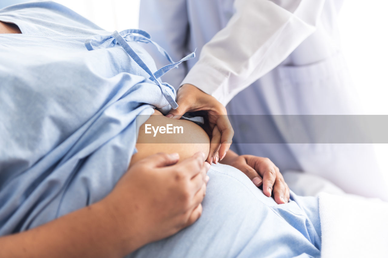 Doctor using a hand to hold the belly fat of obese woman,