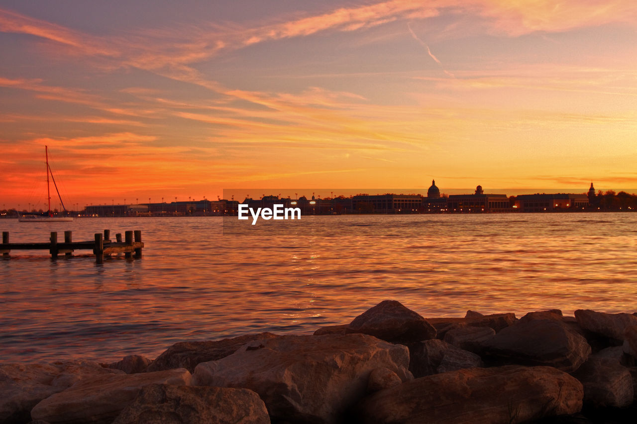 View of lake and cityscape during sunset