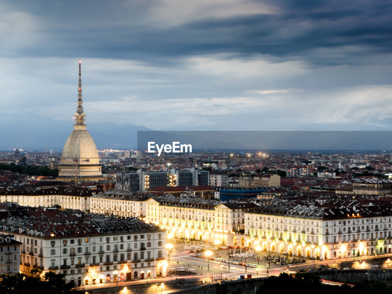 View of cityscape against cloudy sky