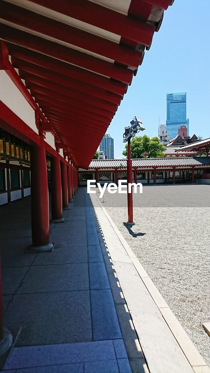 FOOTPATH AMIDST BUILDINGS IN CITY AGAINST SKY