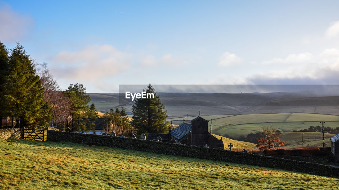 sky, plant, hill, rural area, landscape, tree, nature, cloud, environment, morning, land, scenics - nature, rural scene, architecture, field, grass, beauty in nature, autumn, no people, agriculture, built structure, house, flower, tranquility, day, building, farm, outdoors, tranquil scene, building exterior, growth, sunlight, horizon, non-urban scene