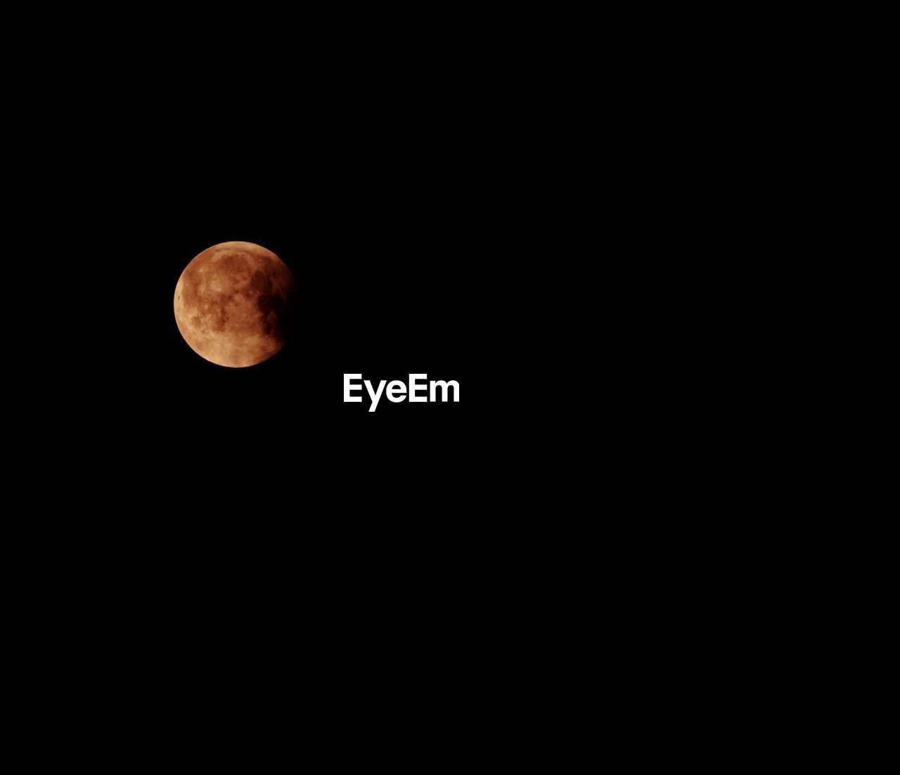 LOW ANGLE VIEW OF MOON AGAINST DARK SKY