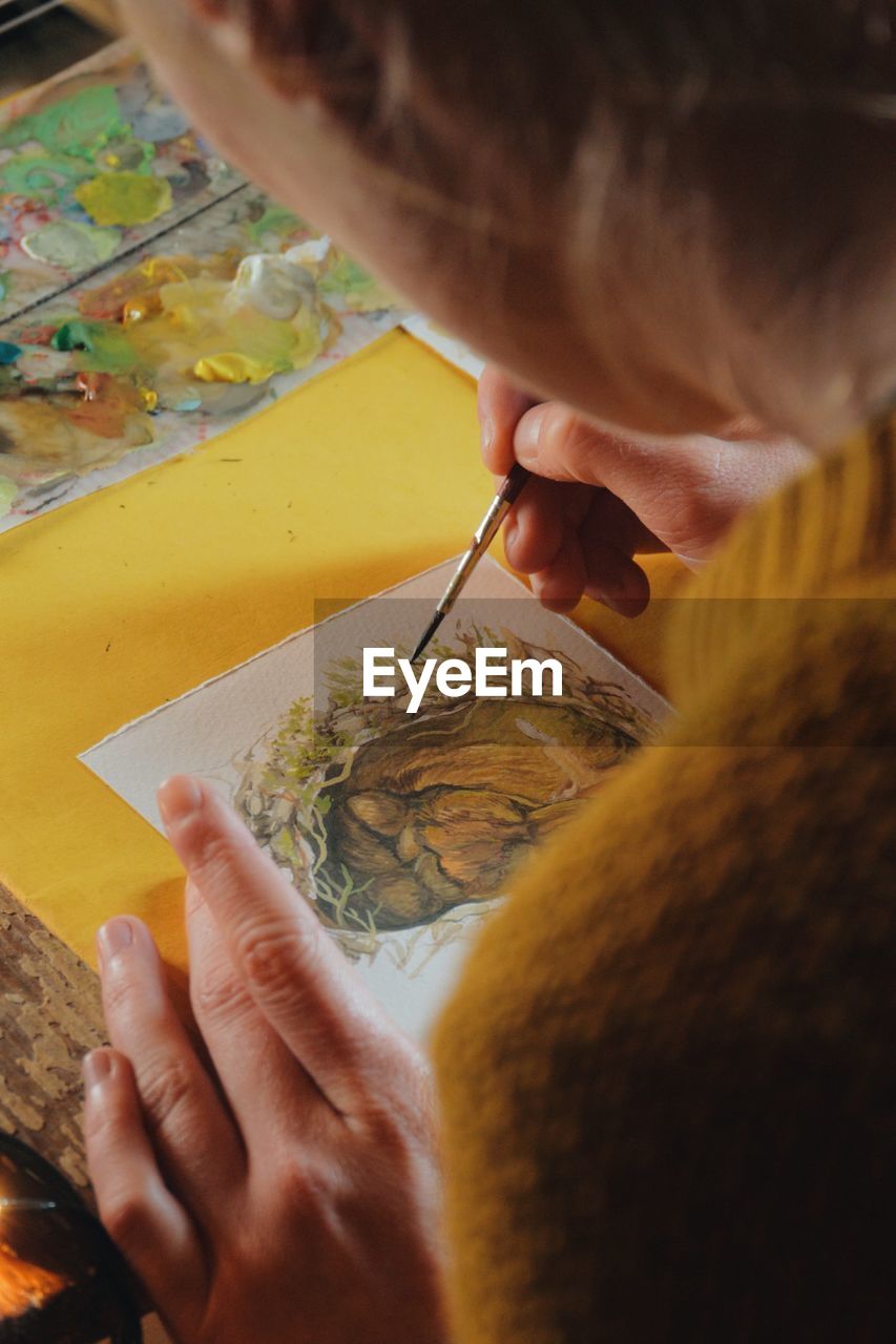 High angle view of woman drawing on paper