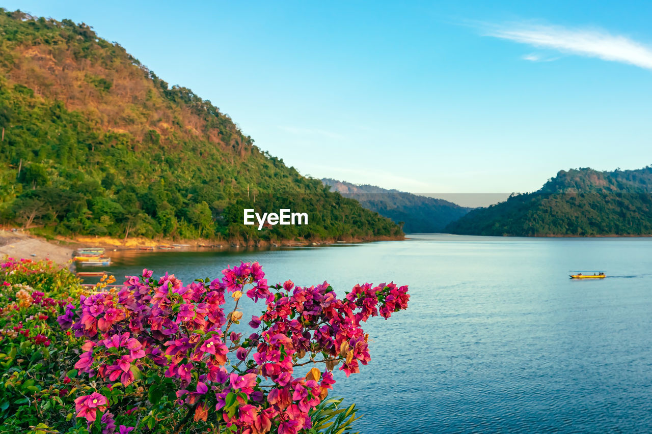 scenic view of lake by mountains against sky