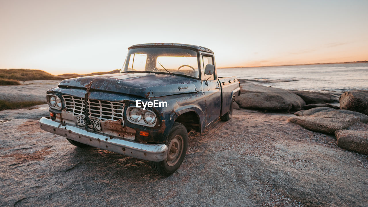 Abandoned car on beach against clear sky