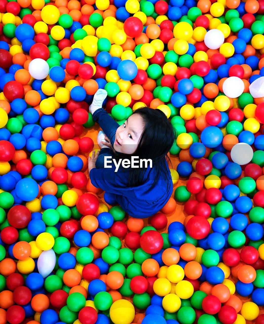 High angle portrait of girl playing in ball pool