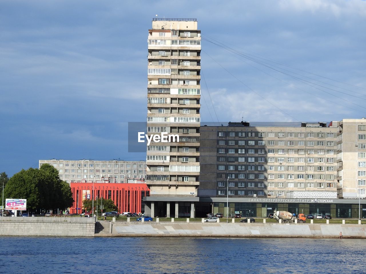 Buildings by river against sky in city