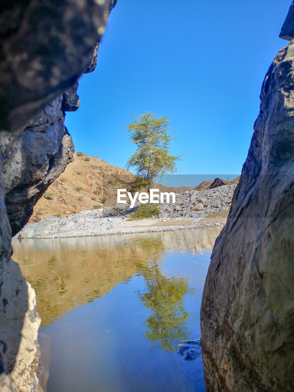 Scenic view of lake and mountains against blue sky