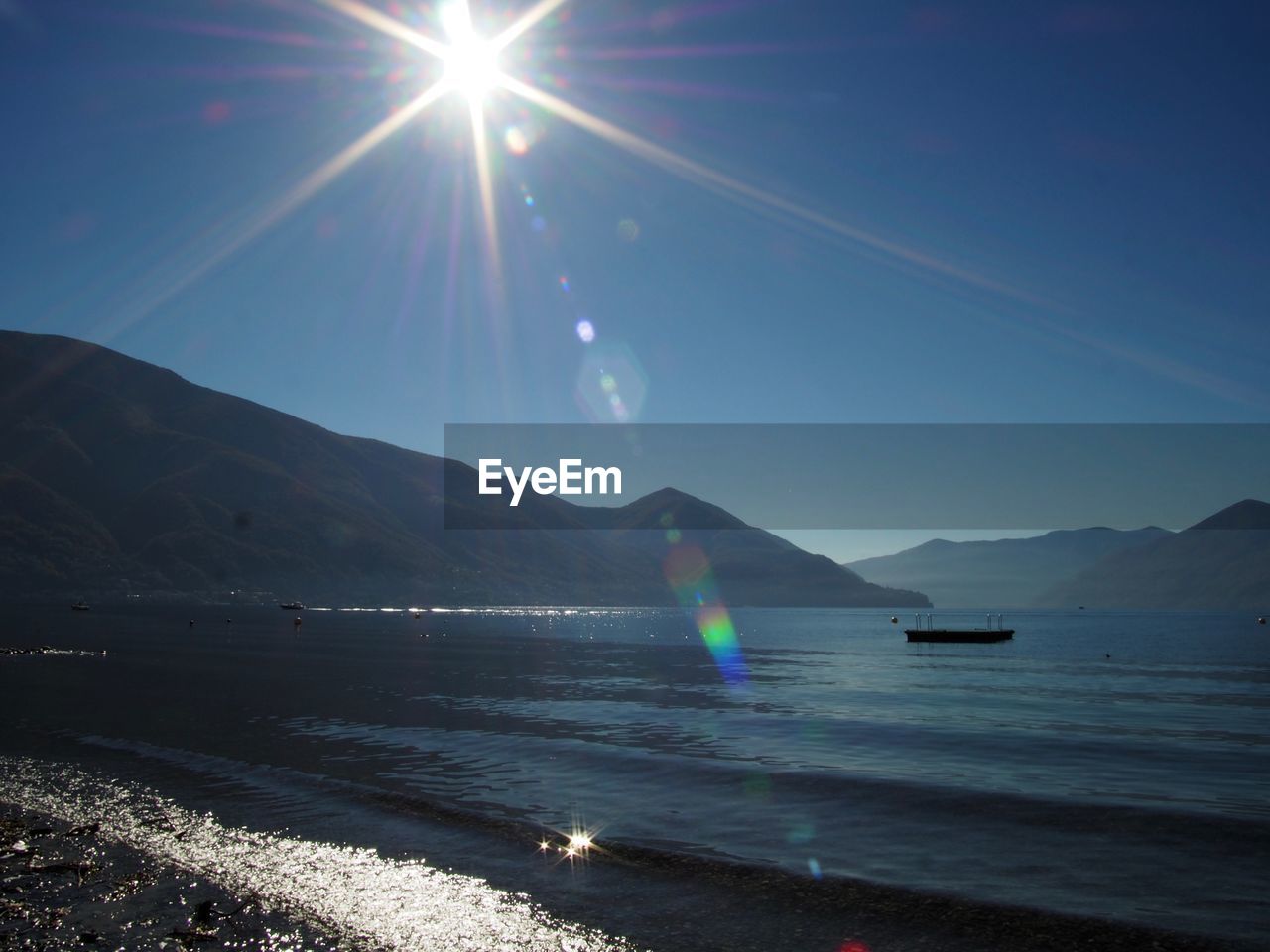 Scenic view of lake against sky on sunny day