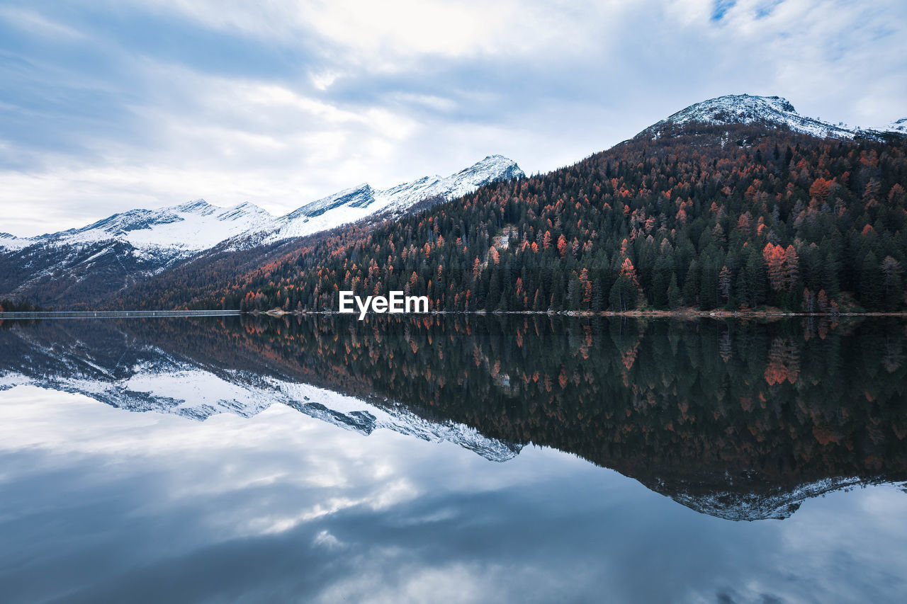 Scenic view of lake by snowcapped mountains against sky