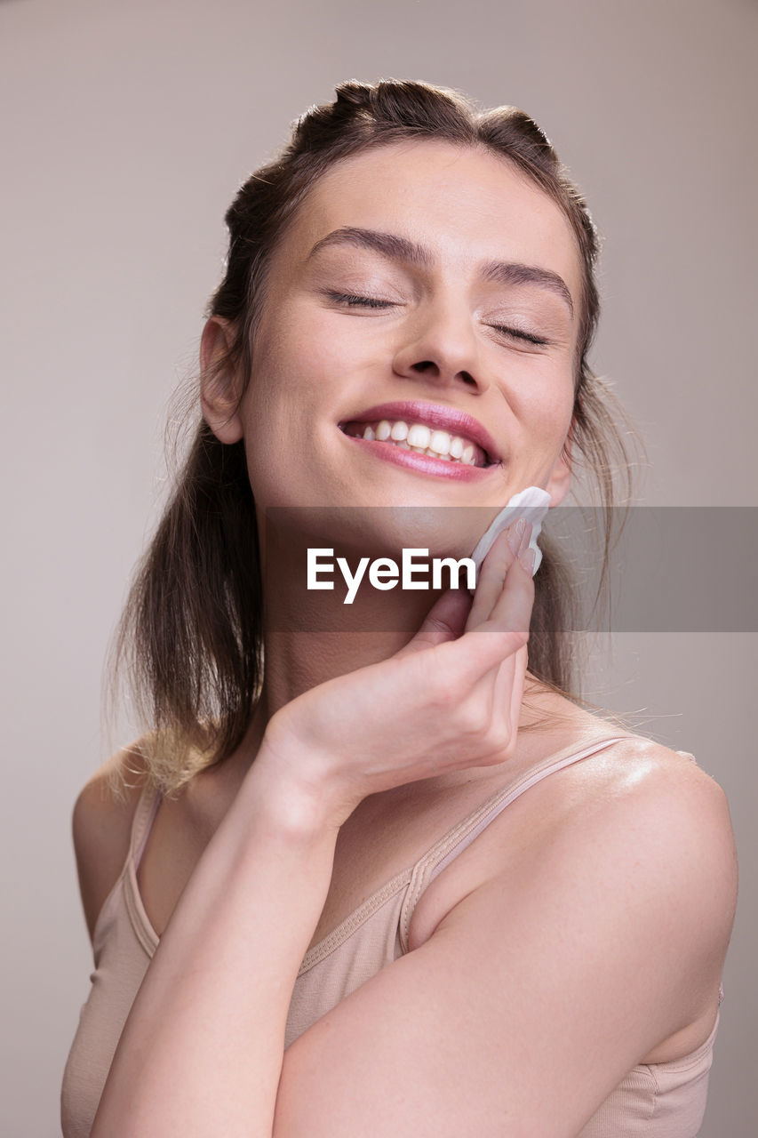 portrait of beautiful young woman against white background