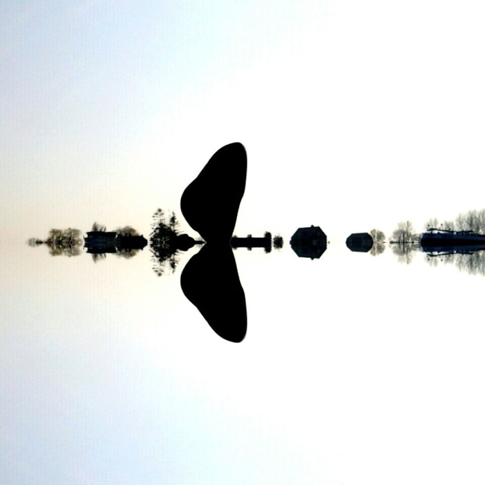 VIEW OF CALM LAKE AGAINST CLEAR SKY