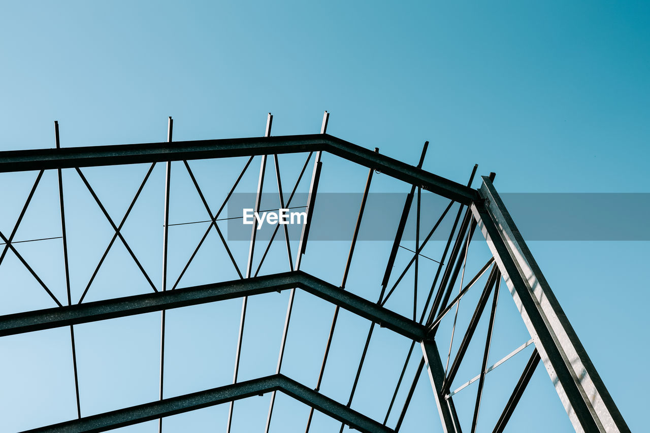 LOW ANGLE VIEW OF METALLIC BRIDGE AGAINST CLEAR BLUE SKY