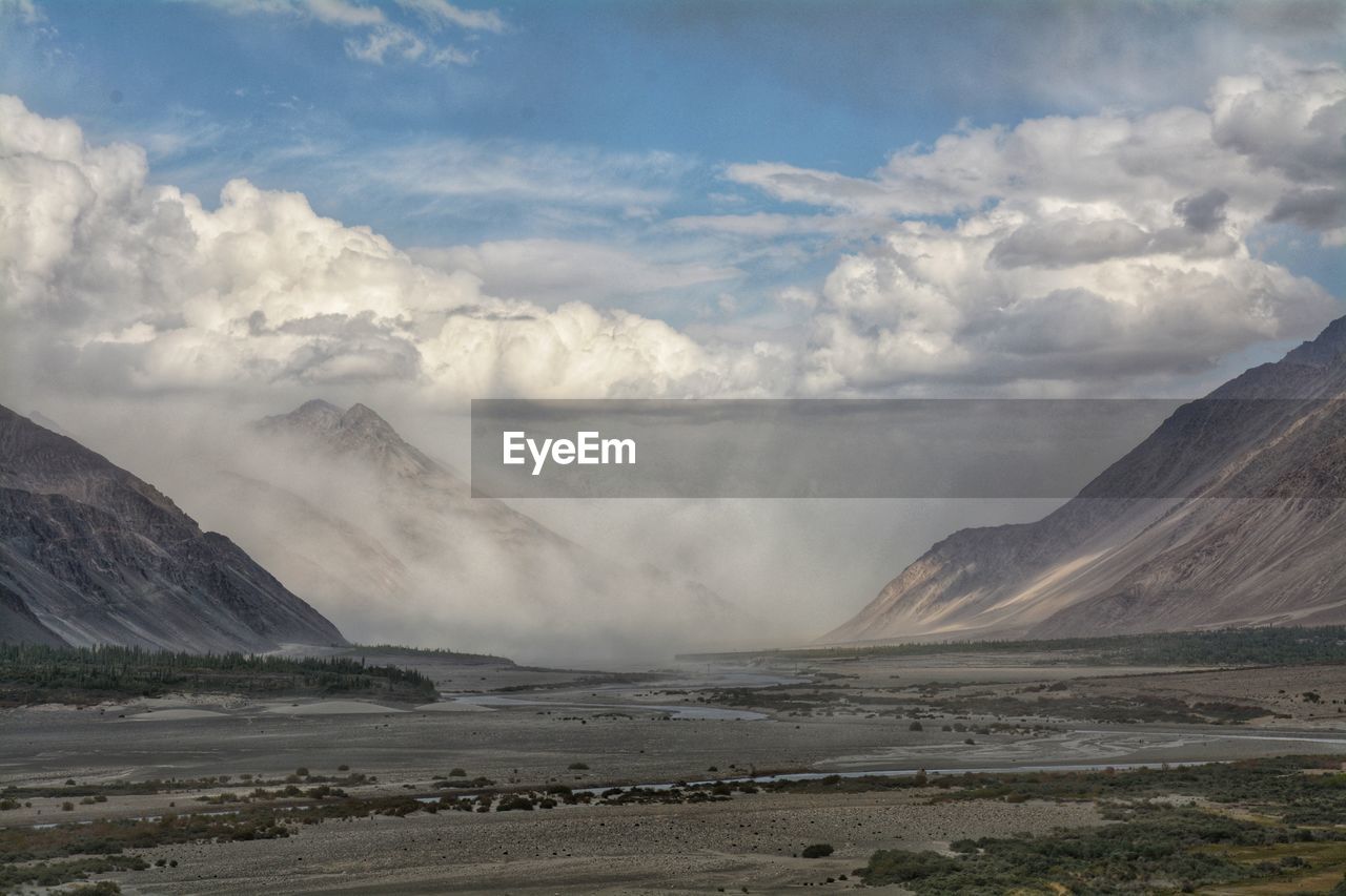 Scenic view of sea and mountains against sky