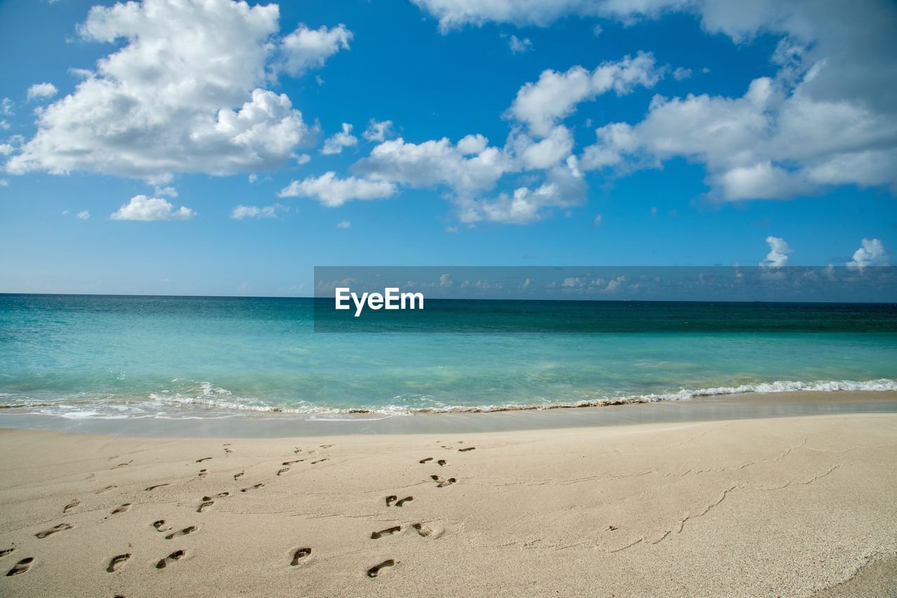 scenic view of beach against cloudy sky