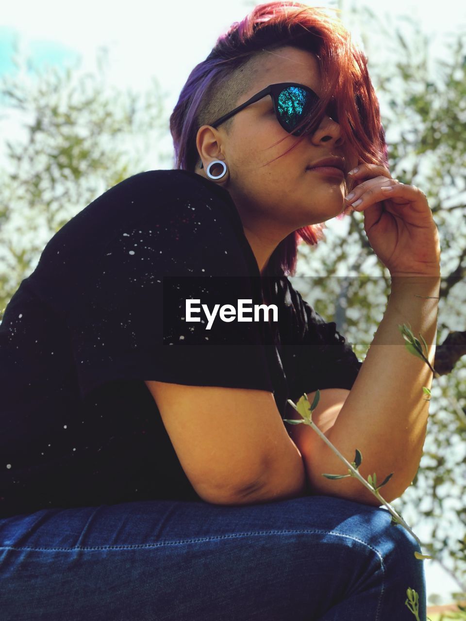 Young woman wearing sunglasses sitting outdoors